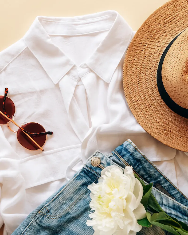 Capi e vestiti in vacanza estiva distesi su un piano